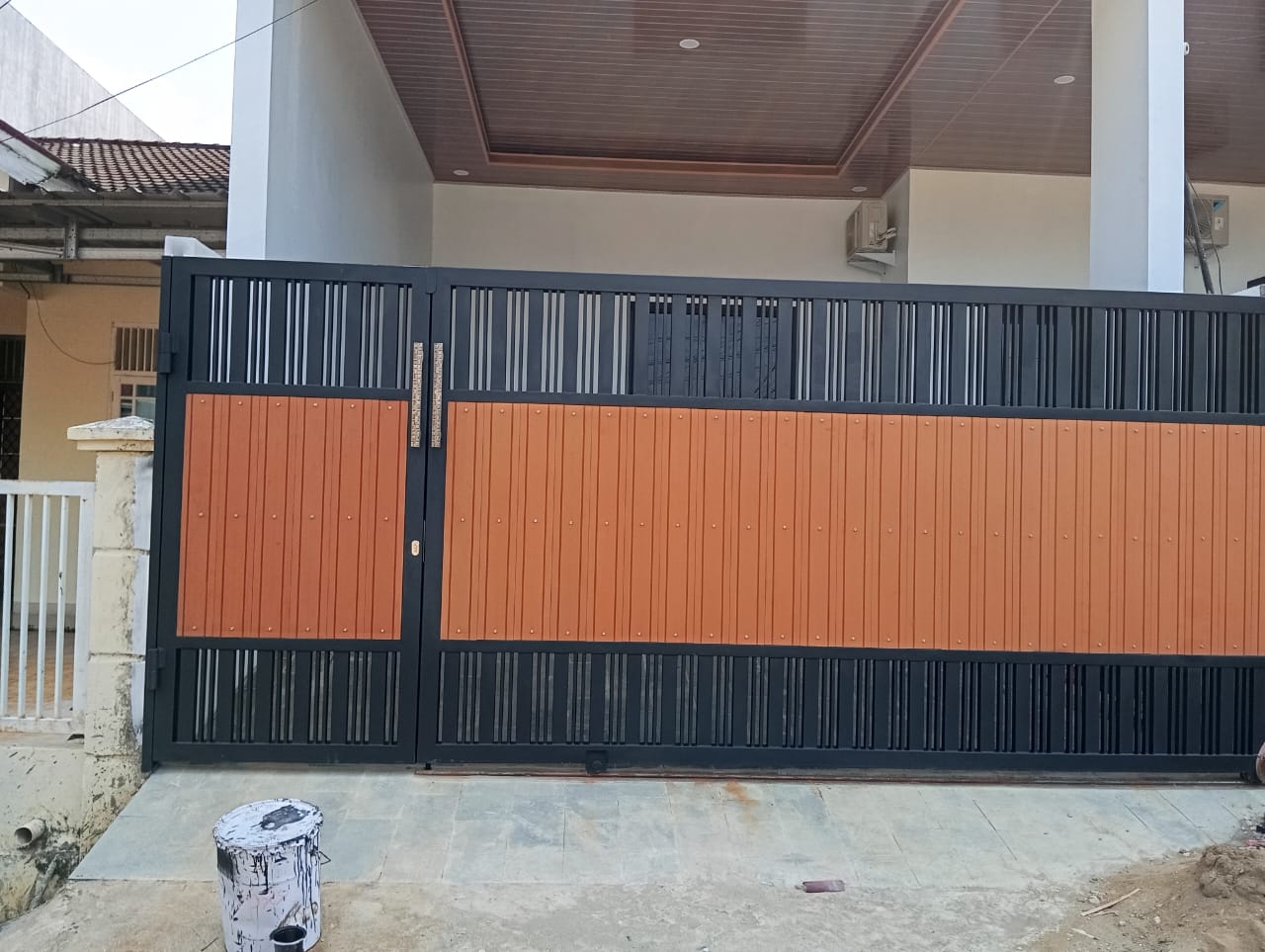 Pagar rumah minimalis hitam dengan panel motif kayu