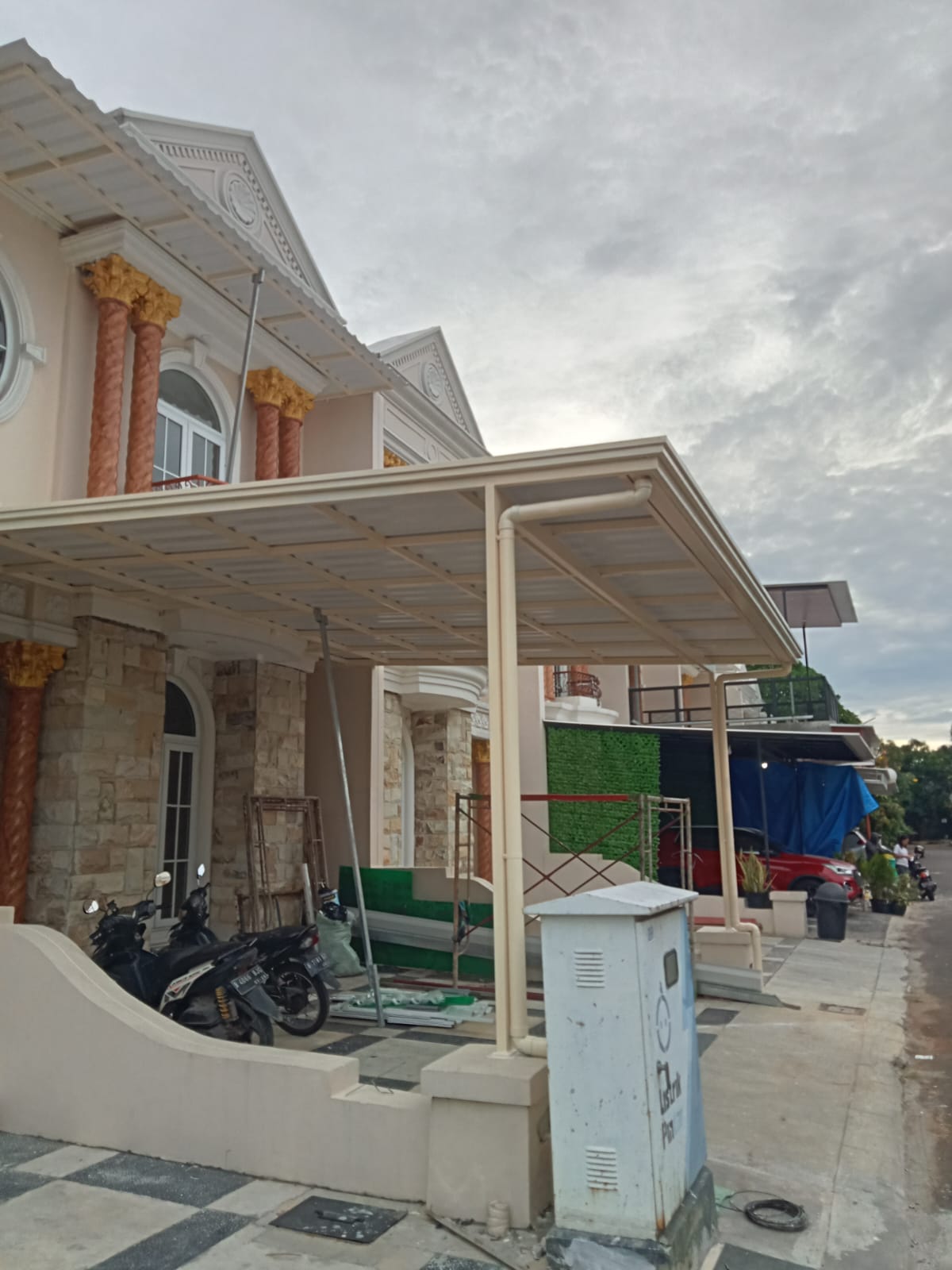 Kanopi teras rumah warna terang dengan tiang besi