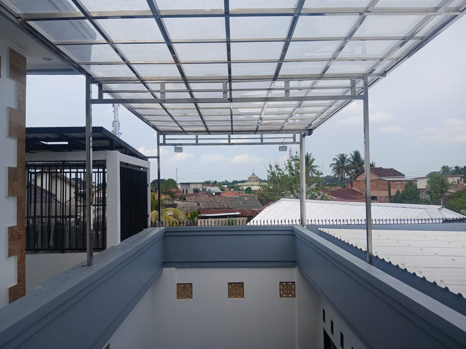 Kanopi balkon dengan rangka besi dan atap transparan