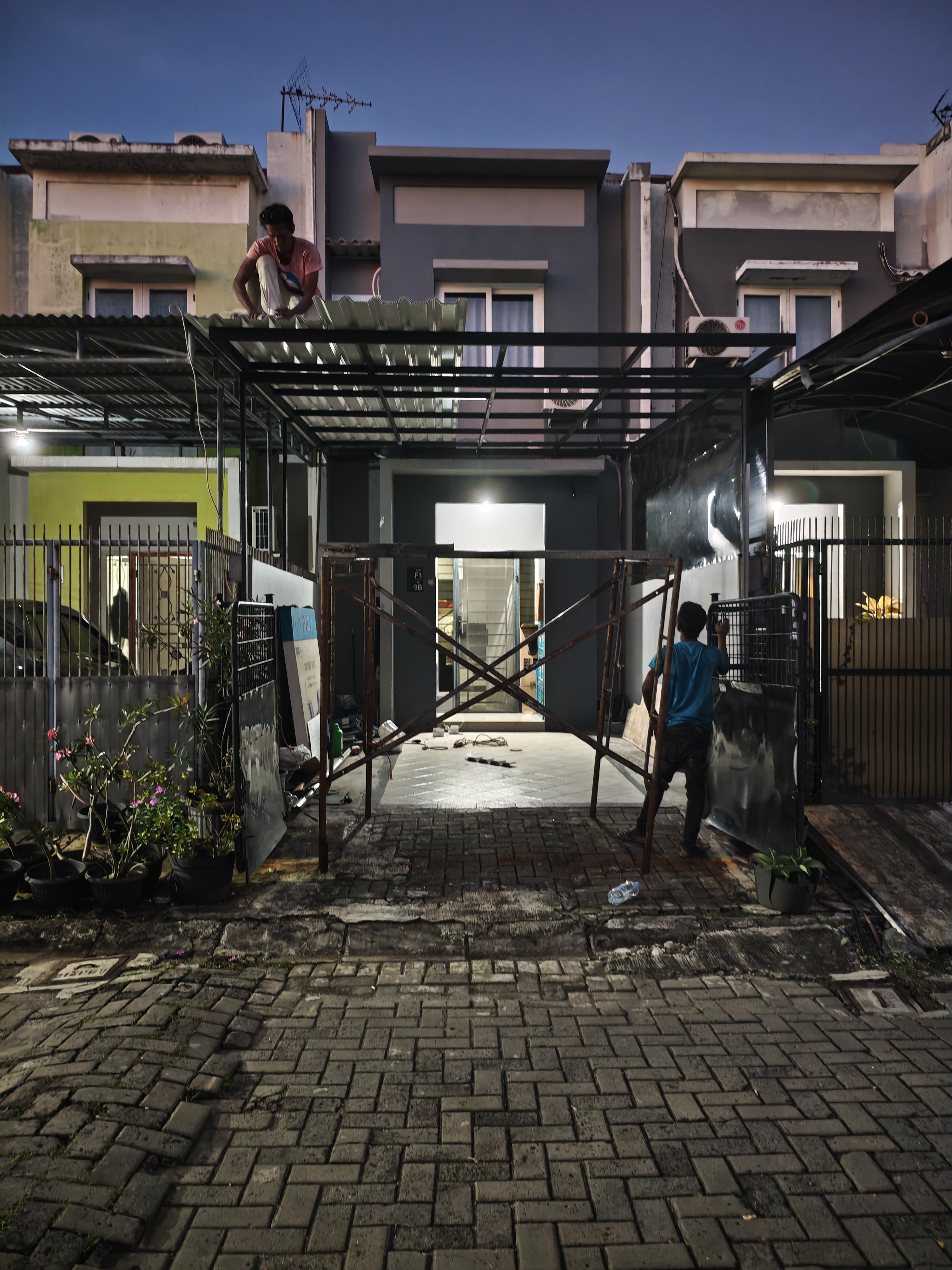 Rangka kanopi besar di area depan bangunan pada malam hari